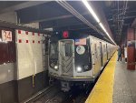 F train with R179 cars stopped at 34th Street-Herald Square Station